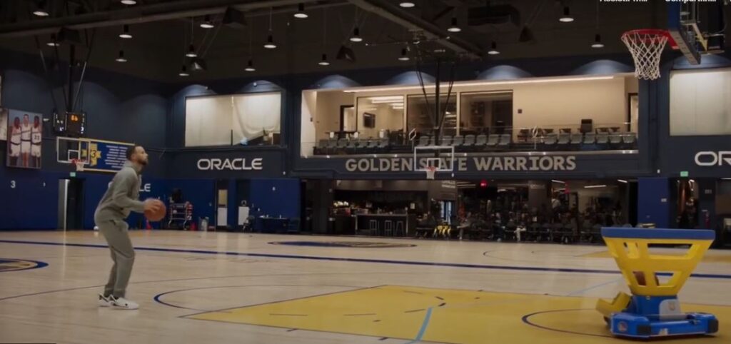 Jogadores como Stephen Curry na prática de arremessos com um Robô
